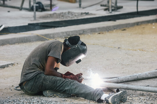 blacksmith welding metal structure wearing helmet