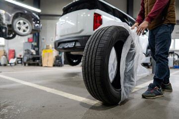Mechanic unpacking new tires in a garage. 