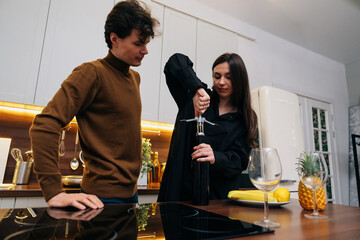 A couple preparing to enjoy wine together in a modern kitchen at home