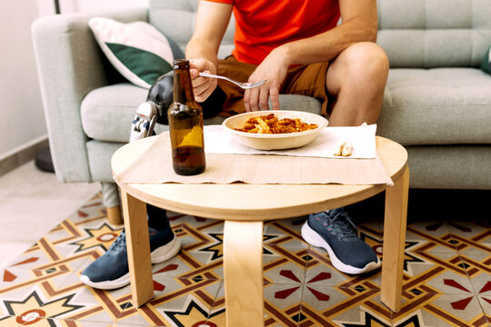 Man with Prosthetic Leg Eating Meal at Home Table