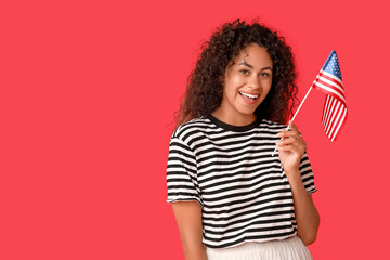 Young African-American woman with USA flag on red background