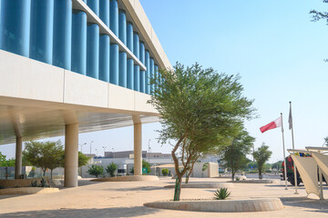 Qatar National Library in Doha with the Qatar flag waving next to it