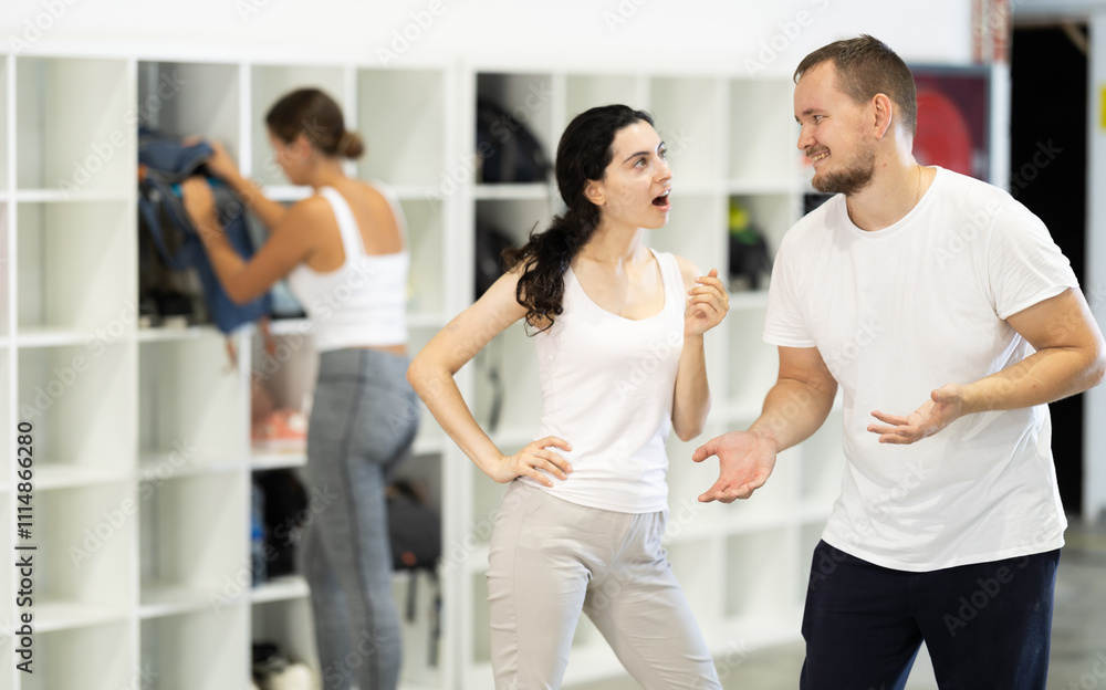 Wall mural Man and woman, young rock climbers laugh and share stories in the changing room of a climbing wall after an exciting successful training session