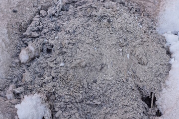 gray white texture of ash with sand and white snow in the winter street