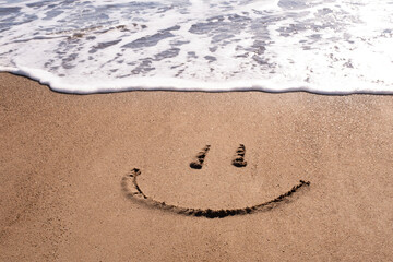 Smiley face emoji on the beach