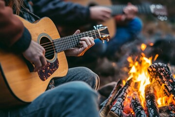 Obraz premium Young adults playing acoustic guitars by campfire in forest setting
