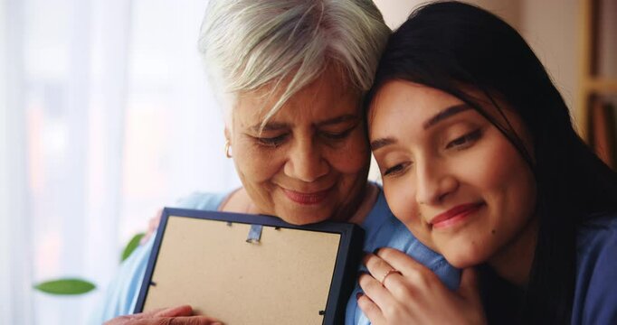 Hug, grandma and woman with picture, love and remember of loss, widow or bonding of family in house. Apartment, embrace and affection for senior person, grieving or granddaughter with support in home