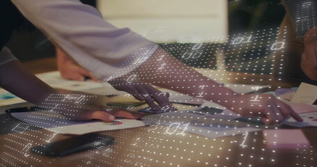 Image of binary coding over diverse colleagues discussing project