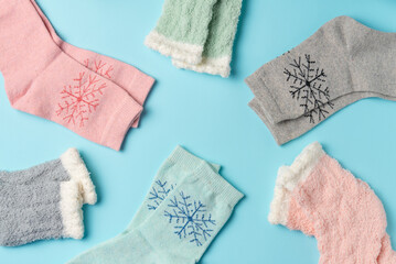 Different winter socks on blue background. Flat lay, top view