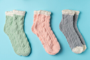 Different warm socks on a blue background. Flat lay, top view