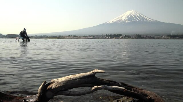 富士山と釣り人を背景にさざ波にゆれる流木、固定撮影、環境音あり