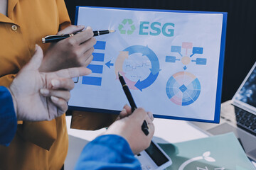 ESG environmental social governance display on laptop on eco-friendly company meeting with business...