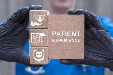Doctor holding wooden blocks sees inscription: PATIENT EXPERIENCE. Health care concept of patient...