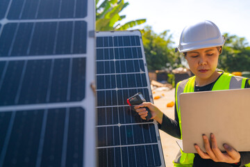Engineer inspecting solar panels using a thermal camera and a laptop for performance testing and...