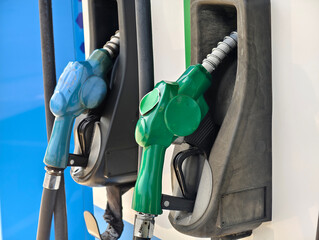 Fuel dispenser nozzles for various types of fuel, arranged at a gas station.