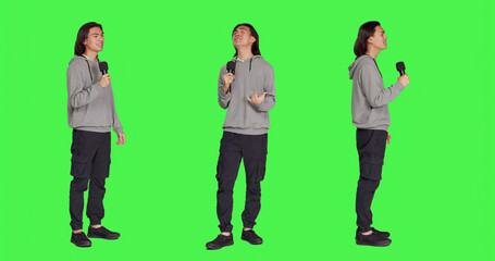 Cool adult doing karaoke session in studio, using microphone to sing trendy tunes and lyrics. Young...