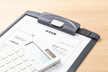 デスクに置かれた価格の見積り書と電卓