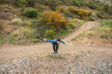 niño jugando y viviendo aventuras en la montaña
