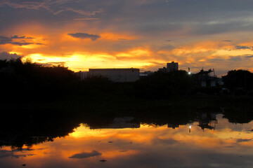 - Panoramic view of the beautiful sunset over the waters of the Caño de la Ahuyama in Barranquilla, Colombia. Water reflection. Vintage film aesthetic.