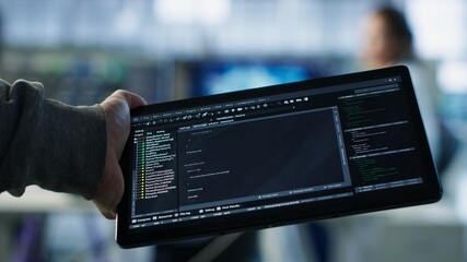 Computer scientist in data center solving tasks on tablet, running programming scripts. Engineer...