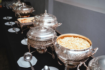 a buffet table with silver plates with food