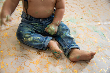 Baby boy,  celebrates his first birthday with a cake smash