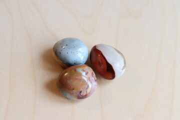 A lot of polychrome jasper or desert jasper on a wood background. A close-up of polished stones and...