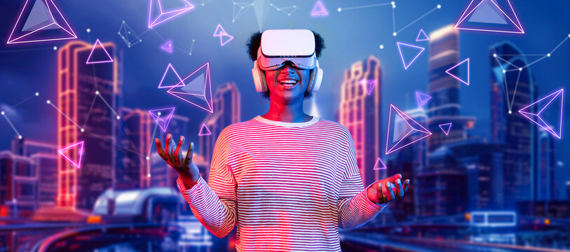 African girl wearing VR glasses and casual cloth while standing at futuristic city. Attractive gamer playing game while using augmented reality technology accessing in metaverse. AI concept Ingenuity.