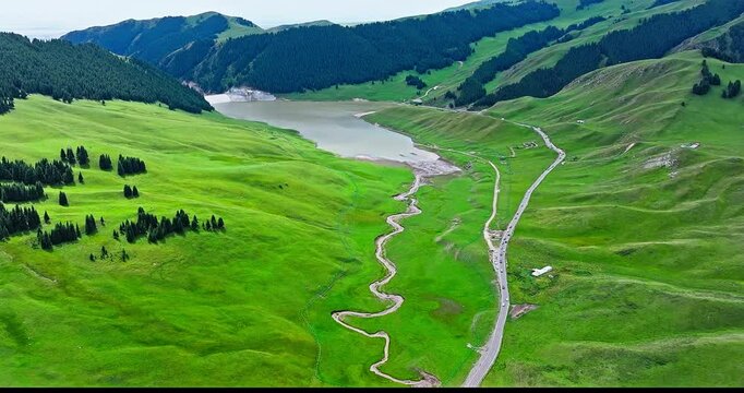 Green grassland and lake with mountain natural landscape in summer. Yizhao Highway is one of the most beautiful highways in Xinjiang, China.