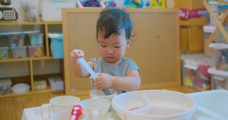 young child holding a syringe while engaging in imaginative play doing chemistry experiments...