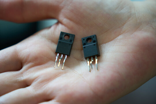 手の上の半導体トランジスタのクローズアップ