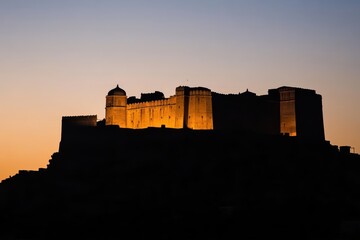 Obraz premium Silhouette of a historic castle illuminated at sunset.