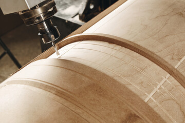 four-axis numerically controlled woodworking machine cuts out complex lines on the canvas. CNC,...