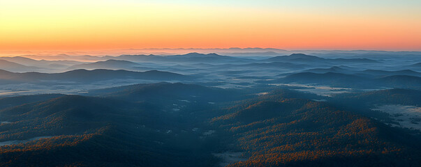 Fototapeta premium Sunrise over misty mountain range.