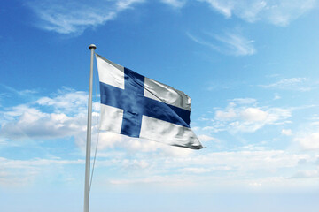Fototapeta premium Waving flag of Finland in blue sky. Finland flag for Republic Day and Independence Day.