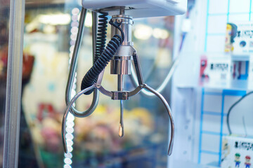 A detailed close-up view of a claw machine's metal gripper, showcasing its mechanical components and functionality. Close-up of a Claw Machine's Gripper in Action.