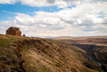 Fototapeta premium Architectural remains of Ani, the medieval city, with rugged landscape, Ani Ruins in Kars province, Turkey, a blend of history and nature