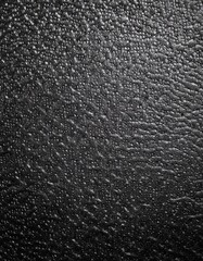 Fototapeta premium Close-up of a black crumpled plastic surface with circular bumps and dimples, glossy texture, abstract industrial feel, high contrast lighting, wrinkled and irregular pattern.