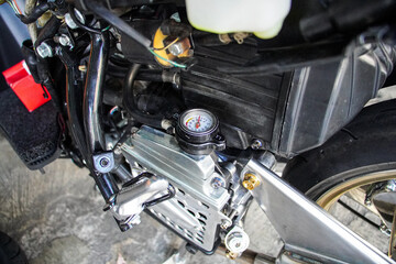Fototapeta premium Detailed view of a modified motorcycle engine, showcasing a custom gauge and various mechanical components. Close-up of Motorcycle Engine Components with Gauge