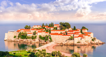 Obraz premium panoramic landscape of sea island sunrise or sunset with beautiful orange roofs and buildings, sea gulf water and scrnic colorful morning cloudy sky on background