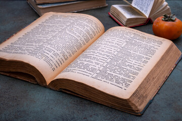 Obraz premium Close-up of several old dictionaries against a dark background. Selective focus
