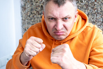 portrait of an aggressive angry man with a face distorted with hatred and malice