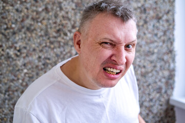 portrait of an aggressive angry man with a face distorted with hatred and malice