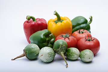 Green round mini eggplants, tomatoes, peppers all healthy vegetables photographed on a white background and base