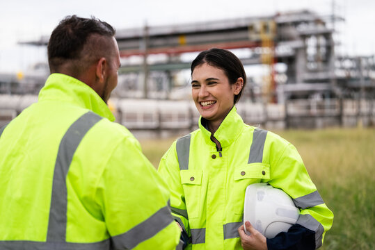 Engineer worker hand shaking to colleagues team for success work at construction site of petroleumchemical industry or refinery oil plant factory