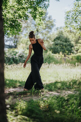 Lovely girl dancing in nature, female dancer performing modern dance in a tranquil natural setting....