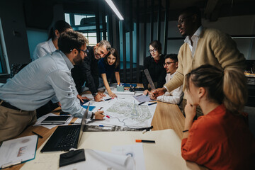 A multicultural group of business colleagues gathers around a table to brainstorm and discuss ideas and solutions. The atmosphere is collaborative, focusing on sharing diverse perspectives and