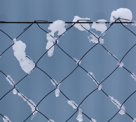 A chain link fence covered in snow