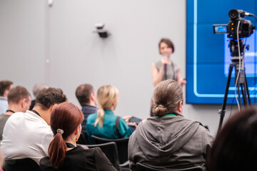 Fototapeta premium Diverse group of professionals attending a conference presentation focusing on business topics. Engaged audience members listening attentively to a speaker at a corporate event.