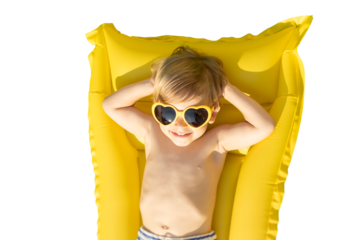Happy child playing outdoor on summer vacation.  Kid lying on yellow inflatable mattress. Transparent  background